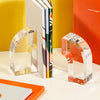 Acrylic Arc Bookends on a  yellow and white background.