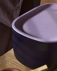 Close up of the Small Navy Storage bin with a Lavender plastic lid on a wooden surface.