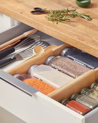 The Open Spaces Drawer Divider inside a drawer separating cooking condiments. 
