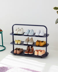 The Open Spaces Navy Entryway Rack on a white background with shoes displayed on it.