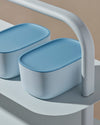 Close up view of two Light Blue Small Storage Bin with Dark Blue Lid on a blue surface.