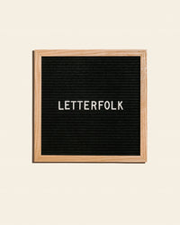 Letterfolk Poet Letter Board in Oak on a cream background.