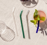 Over head shot of the Glass Straws in Cool Set with a cocktail next to it on a white background. 