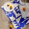 An over head shot of the Linen Tea Towel Set in Blue with oranges on it. 