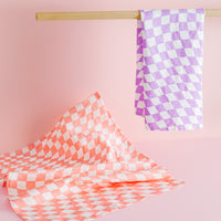 The Linen Tea Towel Set in Checkers on a light pink background.