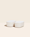 Two Small Cream Storages Bins with plastic lids on a cream background.