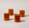 Four 6 oz Amber Double Wall Glasses on a cream background. 