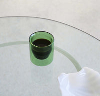 A 6 oz Verde Double Wall Glass filled with coffee on a glass surface. 