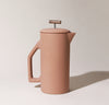 A Matte Sand Ceramic French Press on a cream background.