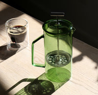 An overhead shot of the Verde Glass French Press on a grayish background. 