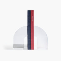 Acrylic Arc Bookends on a white background holding up two books. 